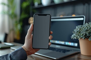 Sticker - Person holding phone in front of laptop on desk