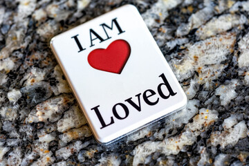 'I Am Loved' Badge on Textured Granite Background