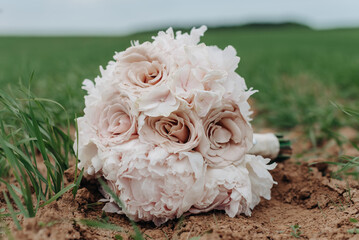 pink wedding bouquet lying on green grass in field, love and family concept