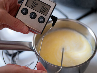 Using a digital food thermometer when cooking. The temperature of a liquid is indicated on a digital display