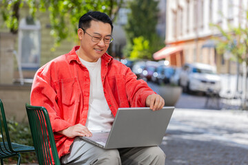 asian middle-aged man freelancer working online distant job with laptop browsing website chatting si