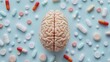 © BritCats Studio - Human brain visualized with a collage of medication pills on a light blue backdrop symbolizing the influence of pharmaceuticals on mental health