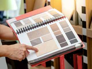 Wall Mural - designer hand pointing at sample wooden material texture on furniture finishing catalog in material 