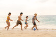© CandyRetriever  - Group of Happy Asian man and woman enjoy and fun outdoor lifestyle travel at the sea on summer beach holiday vacation. People friends playing ball together on tropical island beach at sunset.
