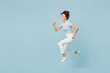 © ViDi Studio - Full body side view fun young woman wears striped t-shirt casual clothes jump high run fast hurry up be in rush isolated on plain pastel light blue cyan background studio portrait. Lifestyle concept.