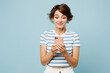 © ViDi Studio - Young smiling happy woman wear striped t-shirt casual clothes hold in hand use mobile cell phone chatting online isolated on plain pastel light blue cyan background studio portrait. Lifestyle concept
