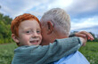 © Westend61 - Boy embracing grandfather at field