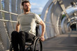 © Westend61 - Man with disability enjoying music through wireless headphone and sitting on wheelchair at bridge