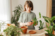 © Westend61 - Girl planting monstera plant in pot at home