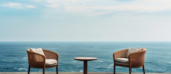 Aufkleber - A lovely set of chairs sit on the balcony overlooking the ocean, creating a tranquil spot with a serene view of the sea and copy space image.