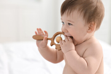 Canvas Print - Cute baby boy with wooden rattle at home