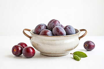 Wall Mural - Plums in a Bowl on a White Table