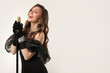 © New Africa - Beautiful young woman in stylish dress with microphone singing on light grey background, space for text