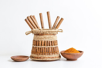 Canvas Print - Wooden sticks in a woven basket with a bowl of spice powder