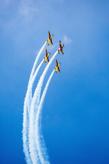 red, yellow and blue airplanes performing stunts in the air. aviation show with airplane aerobatics.