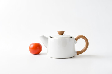 Sticker - White Teapot with Wooden Handle and a Red Ball on a White Background