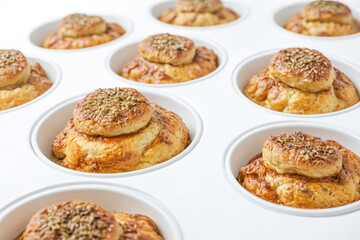 Wall Mural - Close-up of golden brown, baked bread rolls in white ramekins