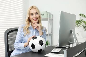 Poster - Happy woman with soccer ball at table in office