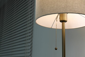 Wall Mural - Stylish lamp near light wall, closeup. Space for text