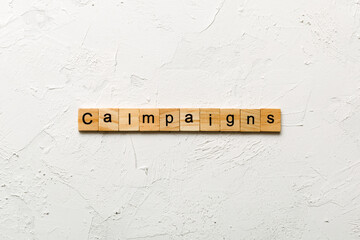 Wall Mural - campaigns word written on wood block. campaigns text on table, concept