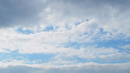 Wall Mural - The autumn sky is a cold blue color. White clouds slowly move across the sky from left to right. Calm and melancholic background on the theme of atmosphere and weather.
