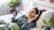 © Sunisadonphimai - woman is happily listening to music on her smartphone and wearing earphones on sofa