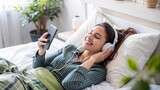 woman is happily listening to music on her smartphone and wearing earphones on sofa