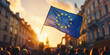 © Helena GARCIA - personas desconocidas de espaldas en una manifestacion con banderas de europa en las calles de una ciudad al atardecer