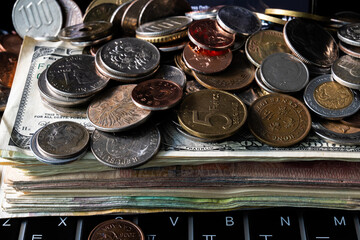 Wall Mural - Pile of various coins on the stack of various banknotes