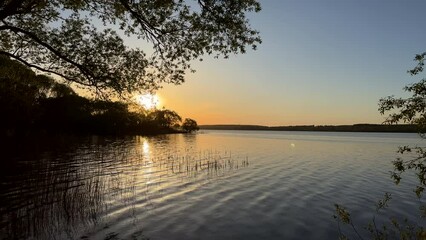 Wall Mural - Sunset over the lake. Awesome Sunset with dramatic clouds  in the sky over sea. Lake in wild nature. 