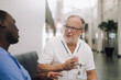 © Maskot - Senior male doctor discussing with colleague while sitting in hospital