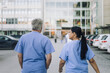 © Maskot - Rear view of male and female doctors walking towards hospital building