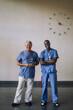 © Maskot - Full length portrait of smiling multiracial doctors standing in front of wall at hospital