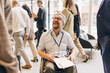 © Maskot - Smiling male entrepreneur with disability sitting on wheelchair during seminar at convention center