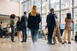 © Maskot - Group of male and female business professionals standing in lobby during seminar at convention center