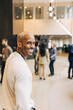 © Maskot - Portrait of smiling male business professional in lobby at convention center