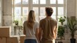 © Антон Сальников - Young couple looking through window at view in new apartment or house at home. Happy couple moving to new house.