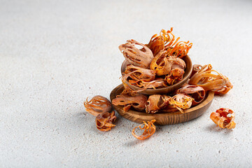 Indian spice mace or javitri in wooden plates on gray background with copyspace.