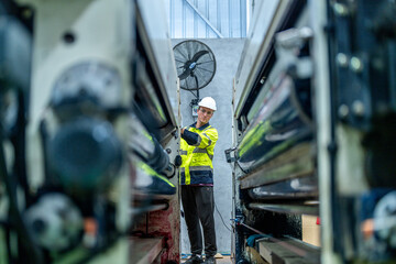 Wall Mural - female engineers in neat work clothes prepare and control the production system of large modern machines in a factory producing industrial technology products.