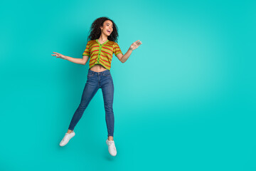 Wall Mural - Full size photo of attractive young woman jump graceful dressed stylish striped clothes isolated on aquamarine color background