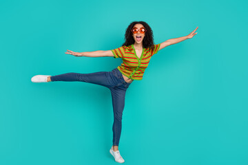 Wall Mural - Full length photo of lovely young lady flying enjoy summer dressed stylish striped garment isolated on cyan color background