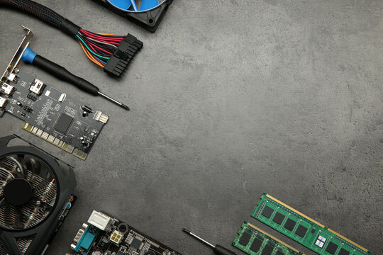 Graphics card and other computer hardware on grey textured table, flat lay. Space for text