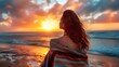 © YASIR  - Young beautiful woman looking at sunset on the beach with a shawl on her shoulders on a fresh evening