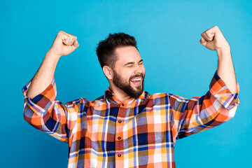 Canvas Print - Portrait of nice young man raise fists wear shirt isolated on blue color background