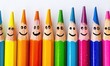 © Daniela - Linear arrangement of colored pencils with drawn happy faces, symbolizing creativity, fun and artistry in education