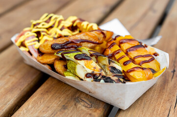 Wall Mural - Loaded fries with melted cheese and various toppings on a wooden table.