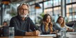 © Iryna - In the office, a senior man leads a business meeting, discussing investment strategies with colleagues