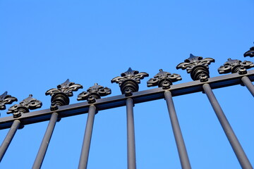 wrought iron spikes on fence isolated on sky