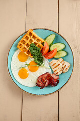 Wall Mural - Elegant Breakfast Plate: Sunny-Side Up Eggs with Belgian Waffle, Bacon, Vegetables, and Cheese