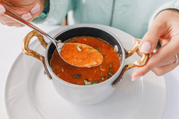 Wall Mural - Close-up of a spoon dipping into a bowl of delicious fish stew, showcasing the mouthwatering flavors of this traditional dish.